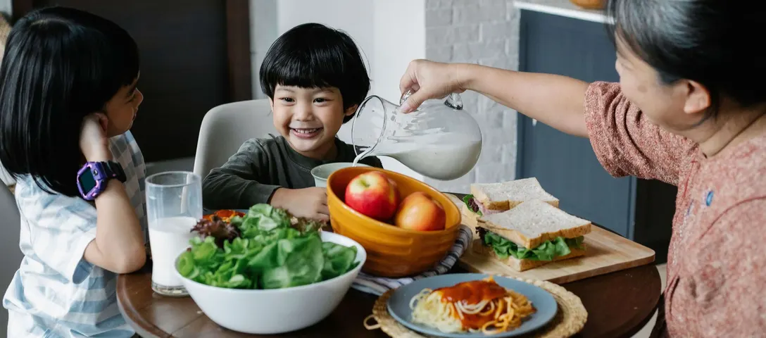 Sekelompok orang menikmati makanan sehat bersama di meja makan